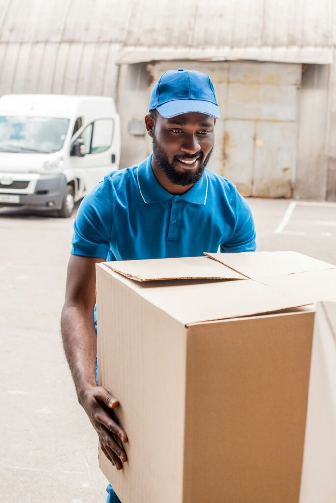 african american delivery man carrying big box
